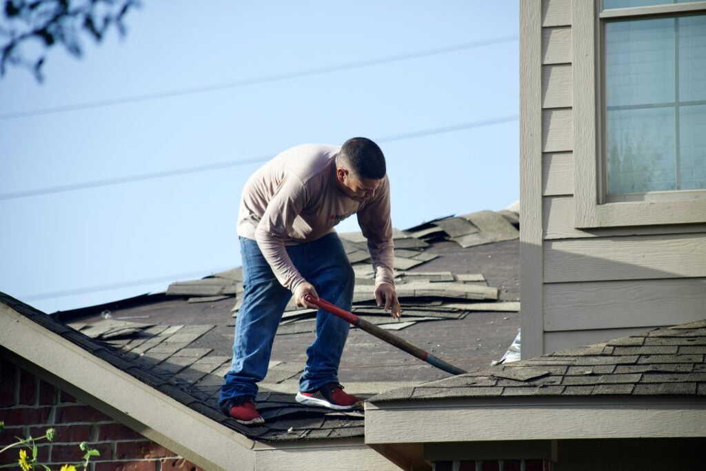 A roofer installing valley flashing on a residential roof to meet Kentucky IRC roofing compliance standards in Louisville