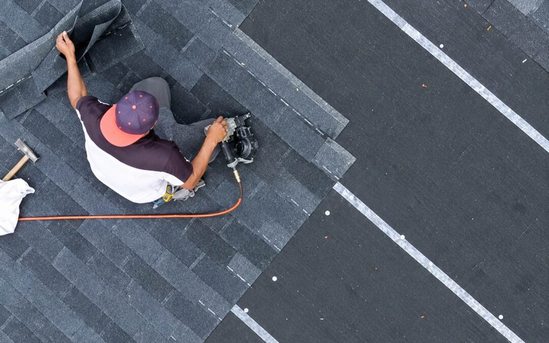 A professional roofing contractor installing shingles on a residential roof