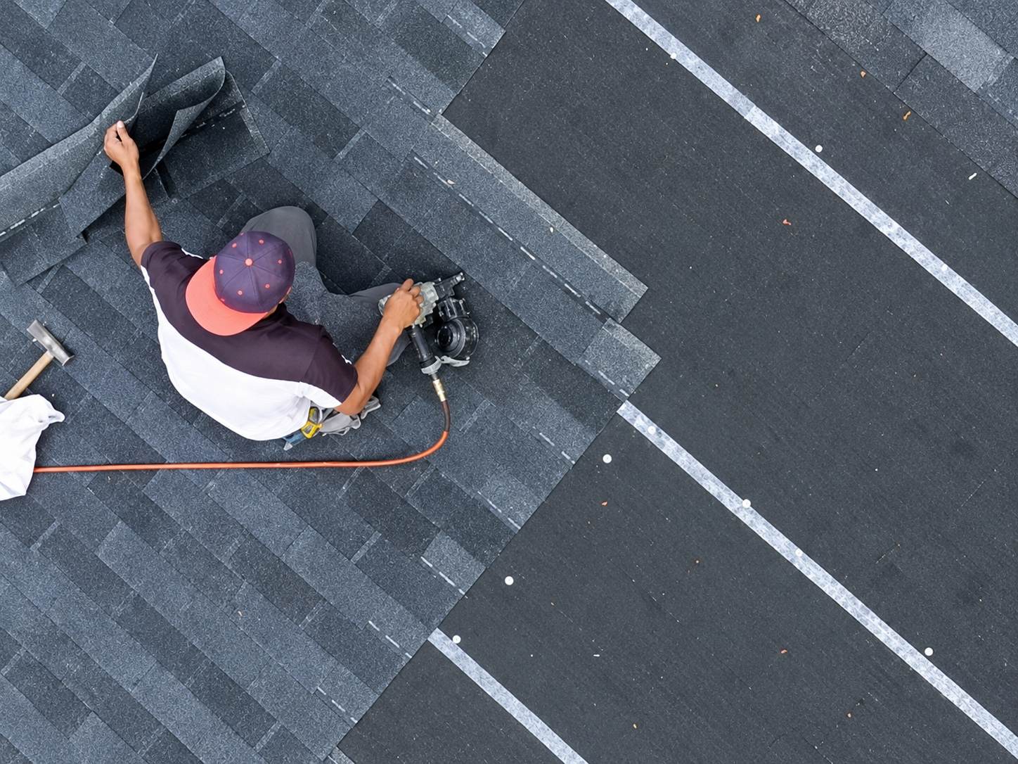 A professional roofing contractor installing shingles on a residential roof